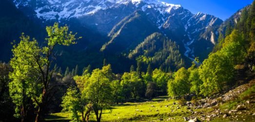 Mountain landscape with green grass, meadows scenic camping Himalayas peaks & alpine from the trail of Sar Pass trek Himalayan region of Kasol, Himachal Pradesh, India.